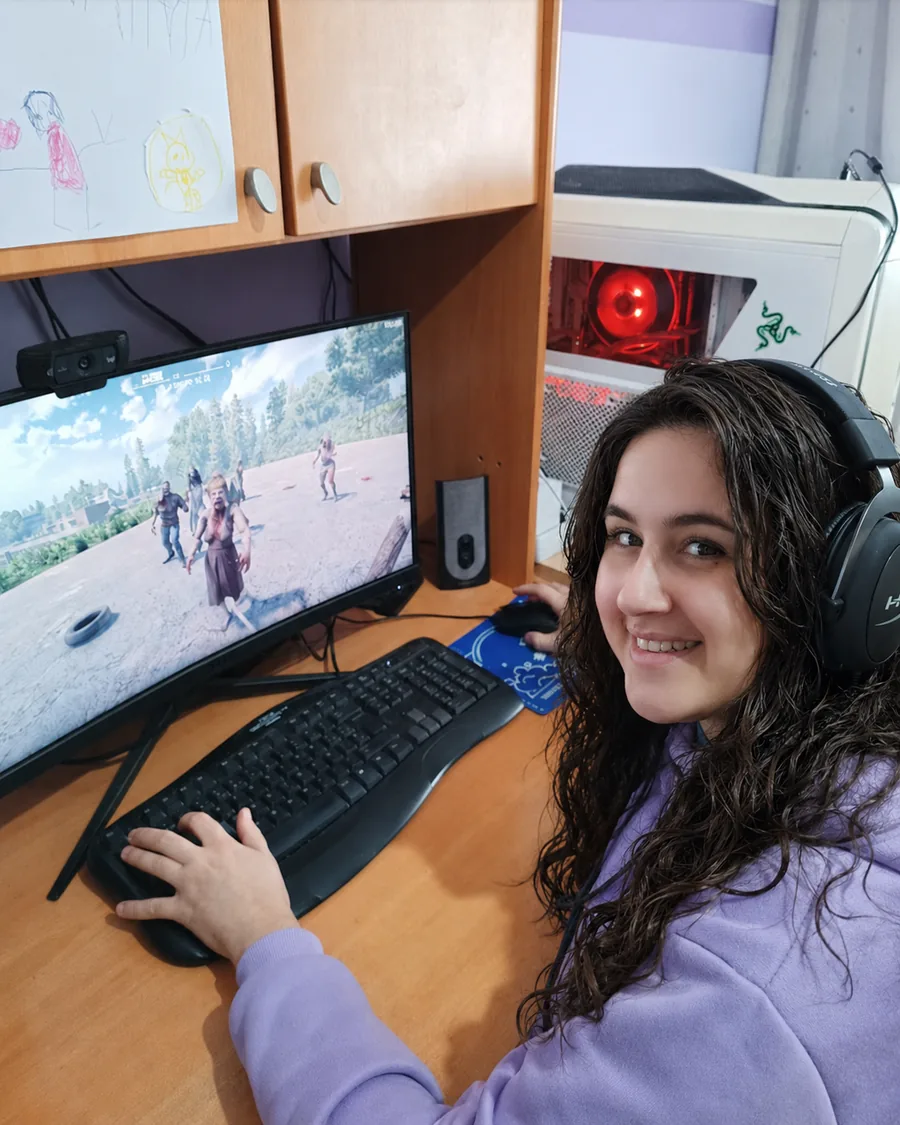 Tamara Bastos jugando en su ordenador, con auriculares puestos y girada hacia la cámara